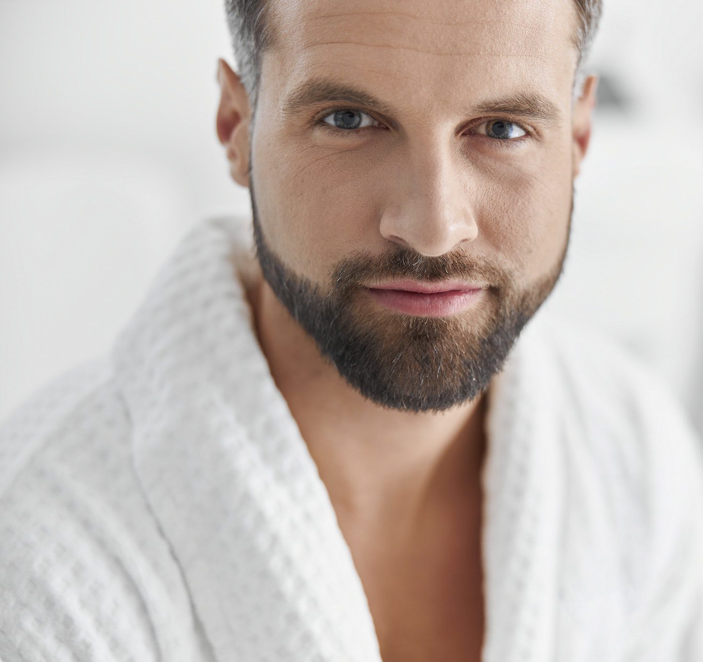 Positive man with styish waits for beauty procedures in cosmetologycal clinic